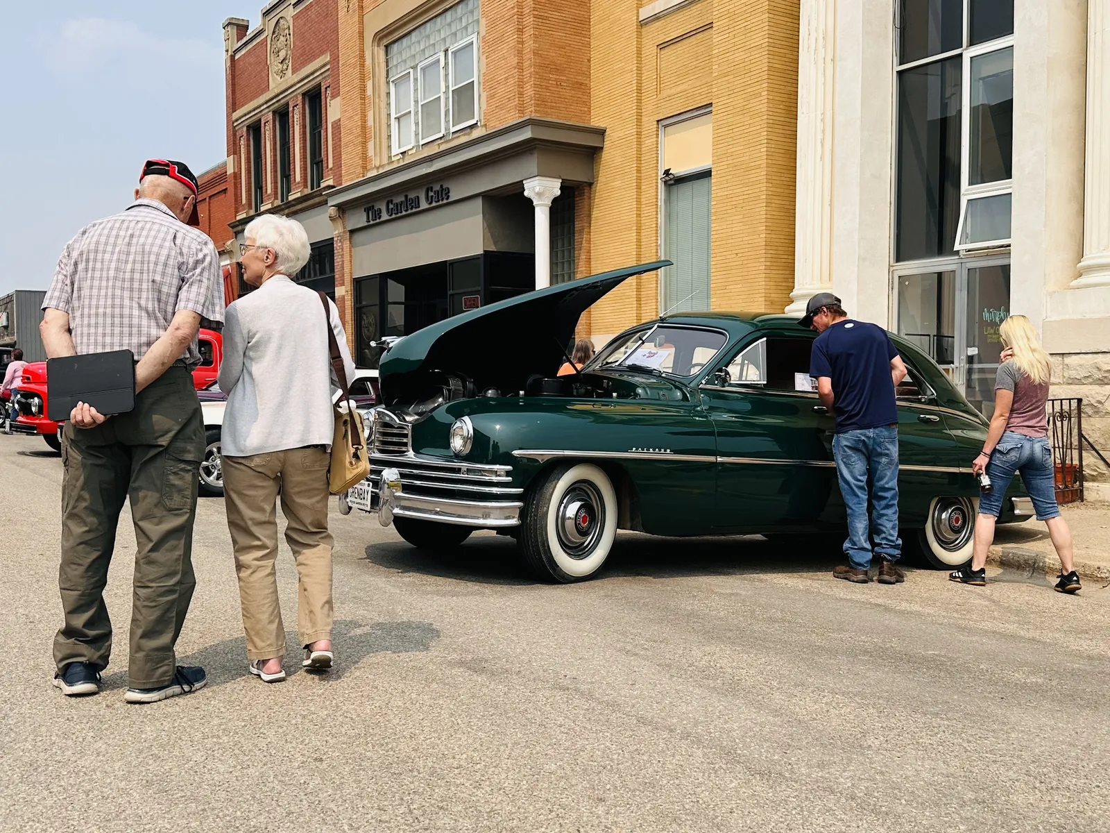 Dark green classic Packard sedan with its hood open on Main Street downtown Carrington