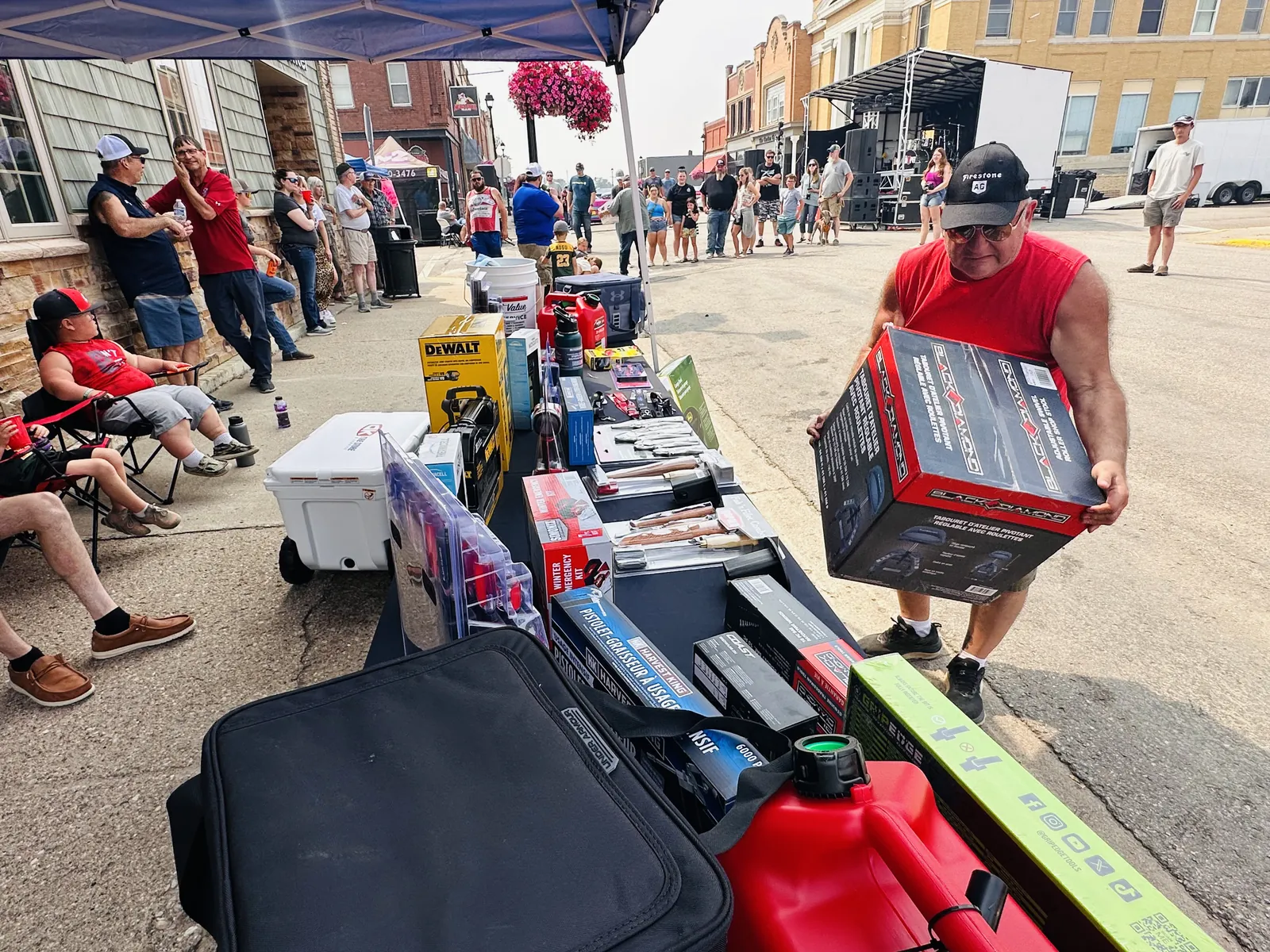 Door prize table loaded with tools and gear, and a winner carrying off a large prize box